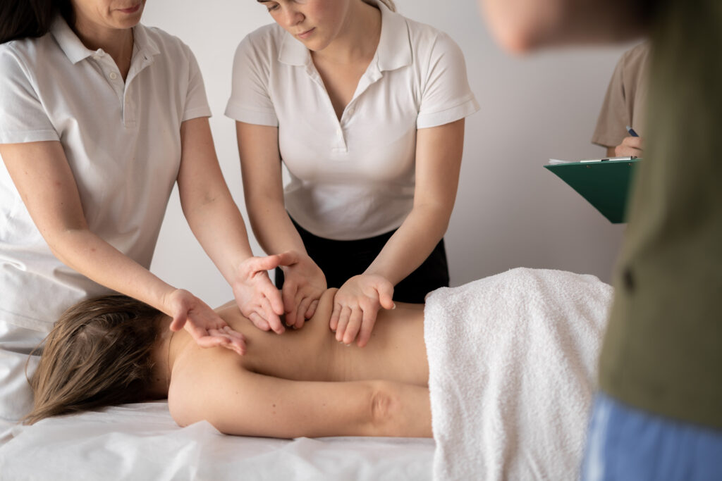 Teacher helping student training to become masseus, health wellness massage training concept