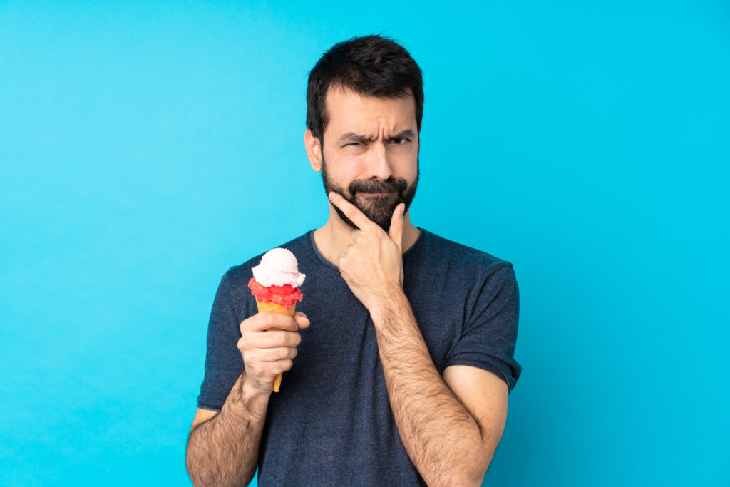 Man questioning ice cream cone in hand